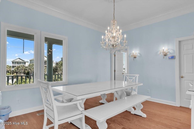 3720 Island Dr, North Topsail Beach, NC 28460 - dining area featuring crown molding, visible vents, wood finished floors, baseboards, and a chandelier