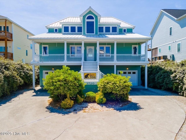3720 Island Dr, North Topsail Beach, NC 28460 - raised beach house with a standing seam roof, an attached garage, concrete driveway, and a porch