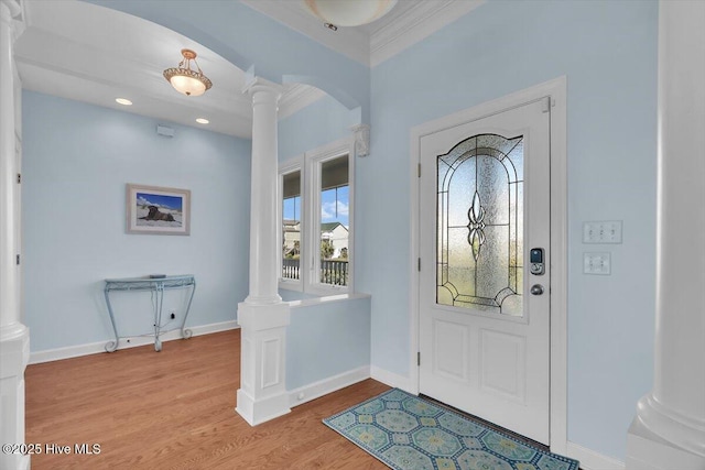 3720 Island Dr, North Topsail Beach, NC 28460 - foyer with crown molding, arched walkways, baseboards, wood finished floors, and ornate columns