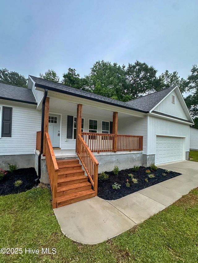 229 Spring Dr, Jacksonville, NC 28540 - view of front of home featuring a porch, an attached garage, roof with shingles, and driveway