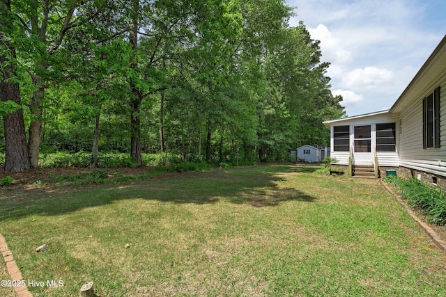 view of yard featuring an outbuilding, a sunroom, and entry steps