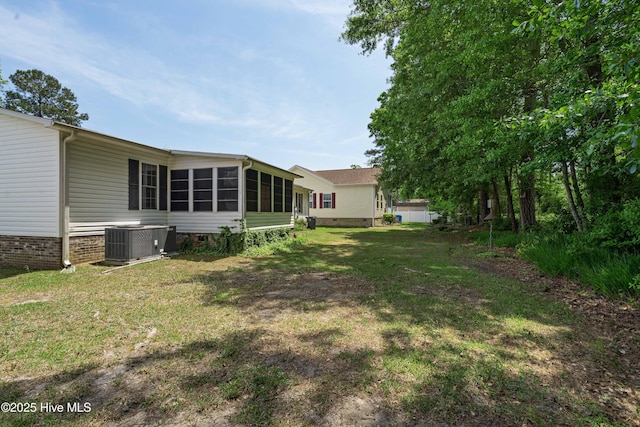 view of yard with a sunroom and central air condition unit