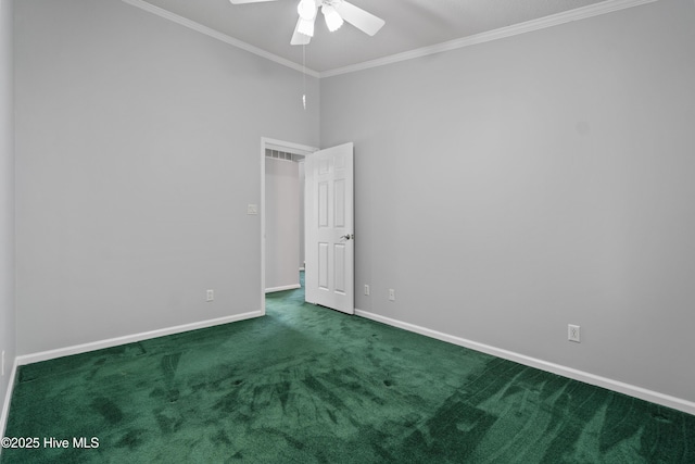 carpeted spare room with a ceiling fan, crown molding, and baseboards