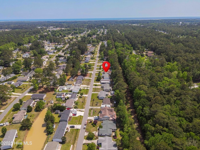 drone / aerial view featuring a residential view and a wooded view