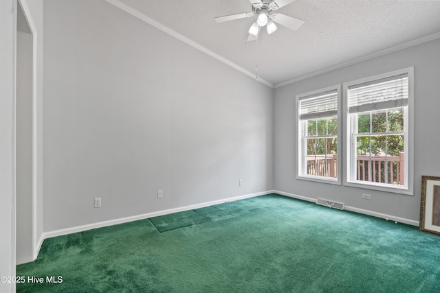 carpeted empty room with crown molding, a ceiling fan, visible vents, and baseboards