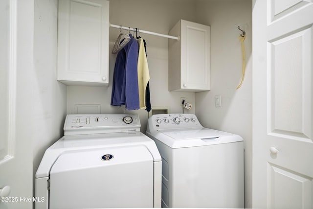 clothes washing area with washer and clothes dryer and cabinet space