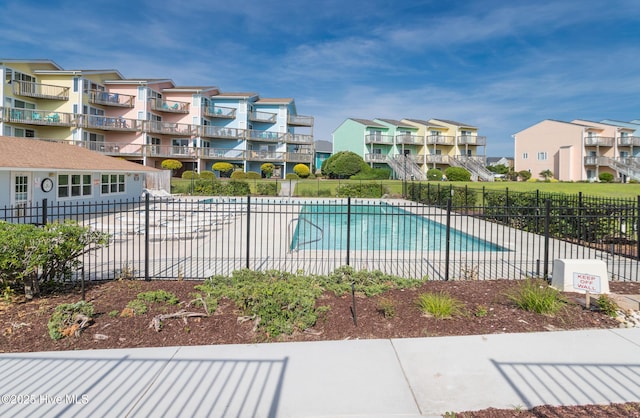 pool with fence and a residential view