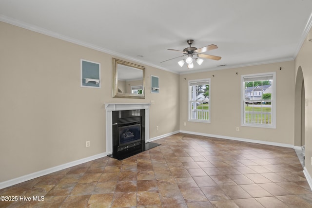 unfurnished living room with crown molding, ceiling fan, a fireplace, arched walkways, and baseboards