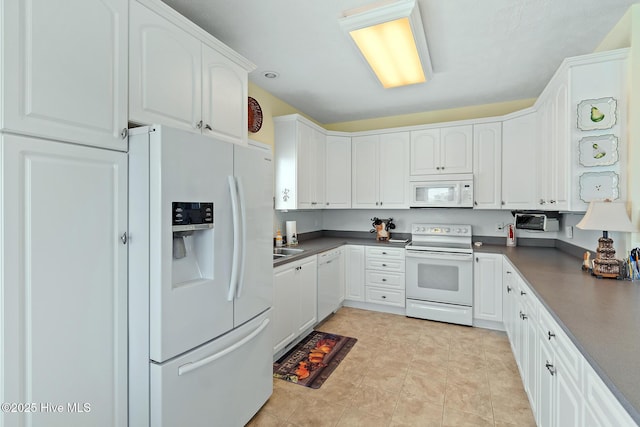 48 Wilmington St, Ocean Isle Beach, NC 28469 - kitchen with white appliances, dark countertops, and white cabinets