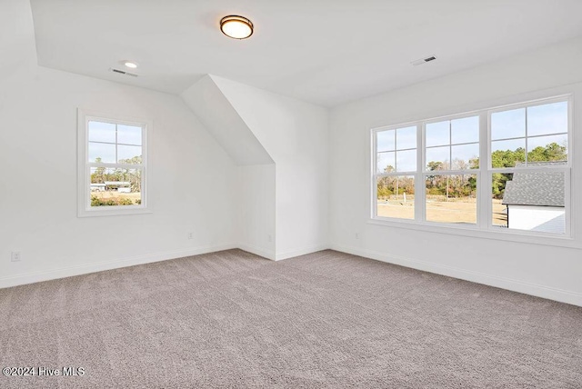 bonus room featuring baseboards, carpet, visible vents, and vaulted ceiling