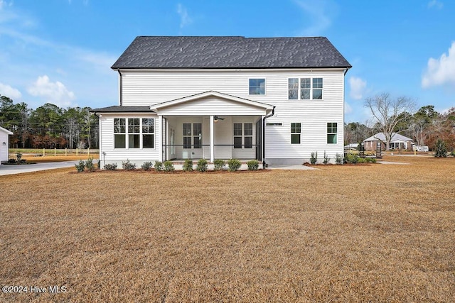 back of property with a lawn, a ceiling fan, and a porch
