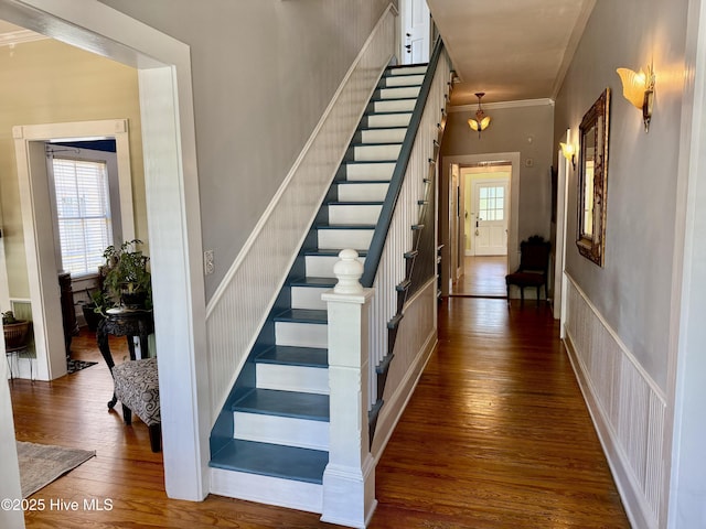 stairway featuring crown molding and hardwood / wood-style floors