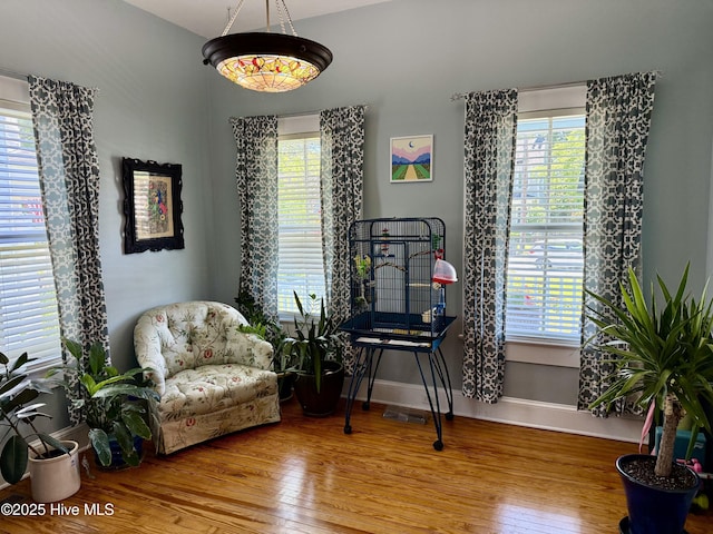 sitting room with baseboards, wood finished floors, and visible vents
