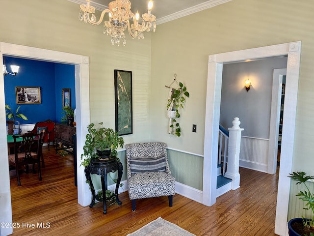 sitting room featuring crown molding, baseboards, wood finished floors, and a chandelier