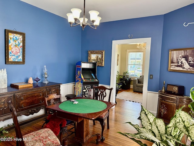 playroom featuring an inviting chandelier, wood finished floors, and a wainscoted wall