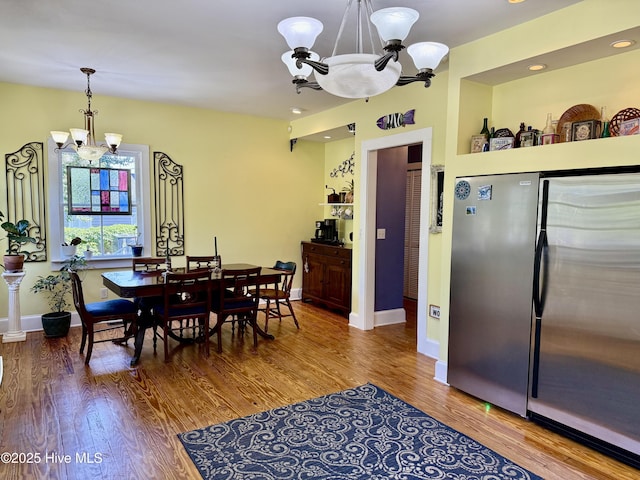 dining room featuring an inviting chandelier, baseboards, and wood finished floors