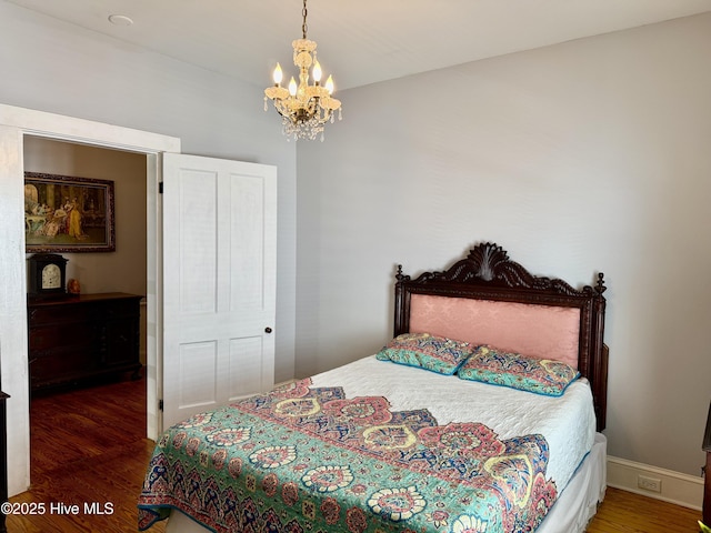 bedroom with an inviting chandelier and wood finished floors