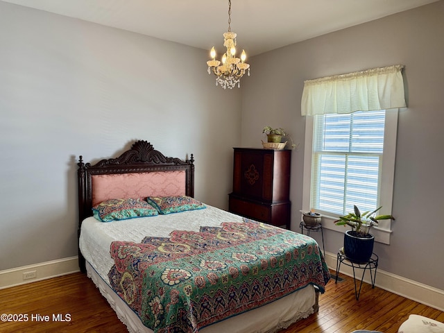 bedroom featuring baseboards, an inviting chandelier, and wood finished floors