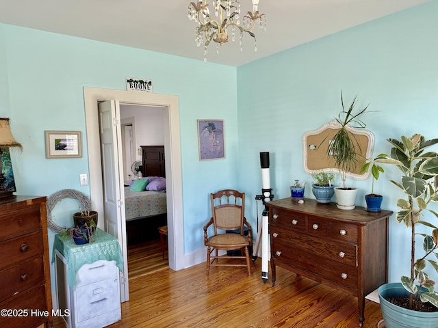 sitting room with an inviting chandelier and wood finished floors