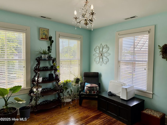 living area with visible vents, a chandelier, and a healthy amount of sunlight