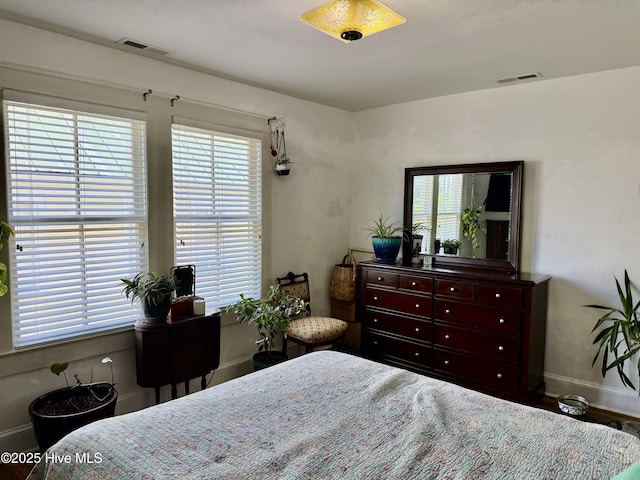bedroom with visible vents, baseboards, and multiple windows