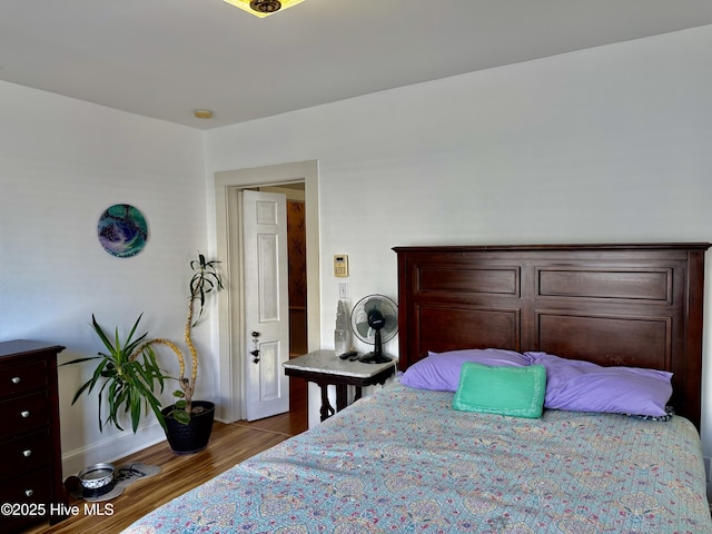 bedroom featuring baseboards and wood finished floors