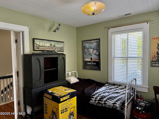 bedroom featuring visible vents and wood finished floors