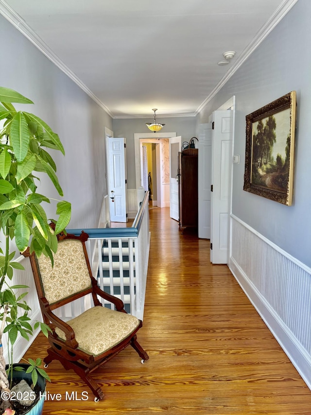 corridor with crown molding and light wood finished floors