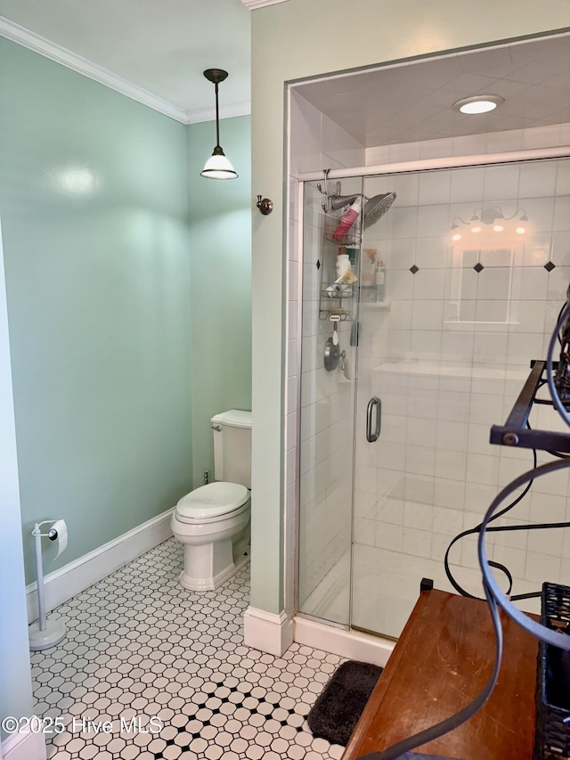 bathroom featuring crown molding, toilet, baseboards, and a stall shower
