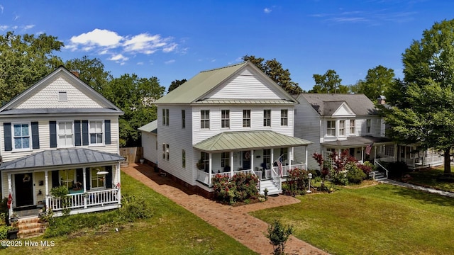 rear view of property with covered porch, a standing seam roof, and metal roof