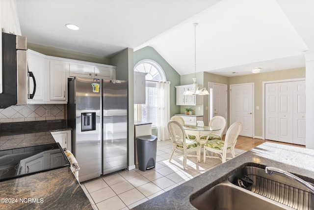 kitchen with a sink, white cabinetry, dark countertops, and stainless steel appliances
