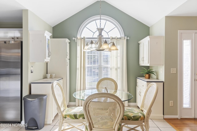 dining space with light tile patterned flooring, a chandelier, plenty of natural light, and lofted ceiling