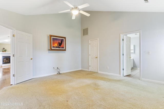 unfurnished bedroom with high vaulted ceiling, baseboards, light carpet, and visible vents