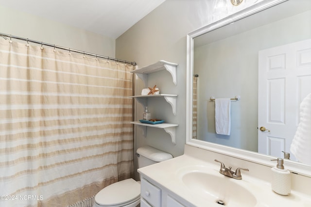 bathroom featuring toilet, a shower with shower curtain, and vanity