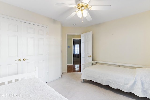 carpeted bedroom with baseboards, ceiling fan, and a closet