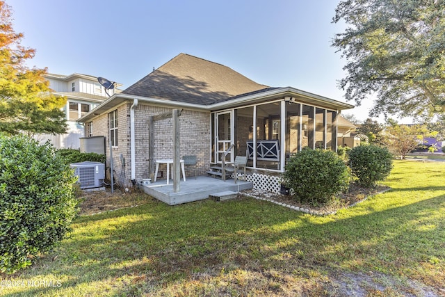 back of house featuring a deck, central AC unit, a sunroom, brick siding, and a yard