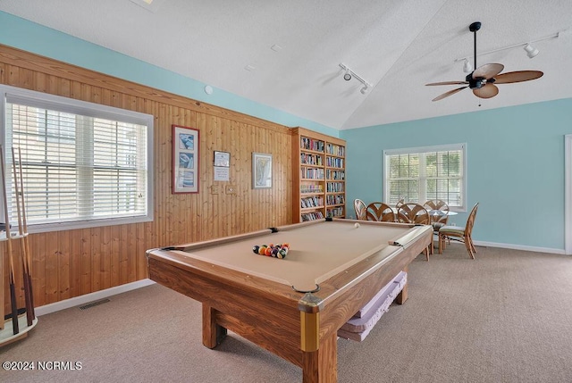 rec room with wooden walls, a ceiling fan, rail lighting, and vaulted ceiling