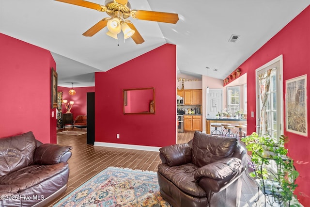 living area featuring visible vents, lofted ceiling, wood finished floors, baseboards, and ceiling fan