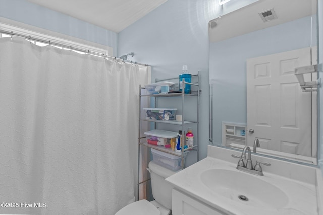 bathroom featuring visible vents, toilet, and vanity