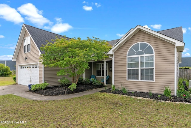 view of front of property featuring roof with shingles, concrete driveway, and a front yard