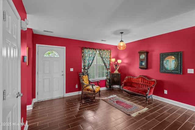 entryway featuring baseboards, wood finish floors, and visible vents