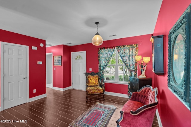 living area with baseboards, wood finish floors, and visible vents