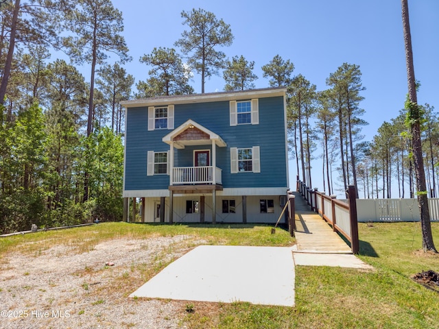 view of front of house featuring a patio, fence, and a front lawn