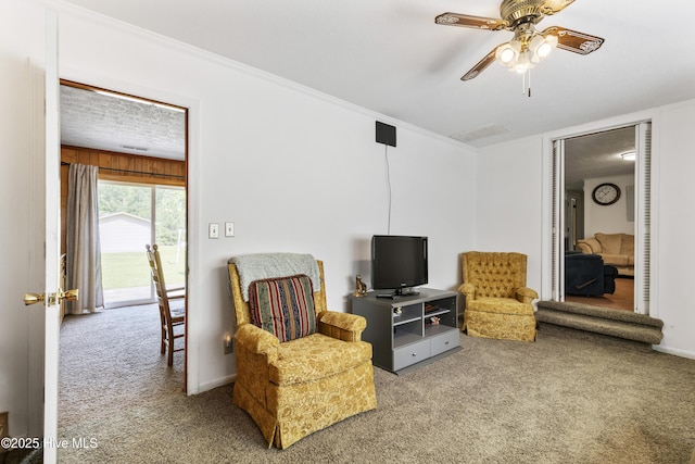 sitting room featuring crown molding, a ceiling fan, baseboards, and carpet