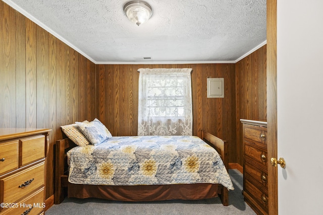 carpeted bedroom featuring visible vents, a textured ceiling, crown molding, and wooden walls