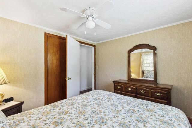 bedroom featuring a closet, ornamental molding, and a ceiling fan