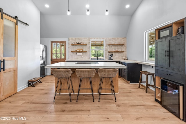 500 Tomahawk Rd, Maple Hill, NC 28454 - kitchen featuring open shelves, wine cooler, stainless steel fridge, vaulted ceiling, and a barn door