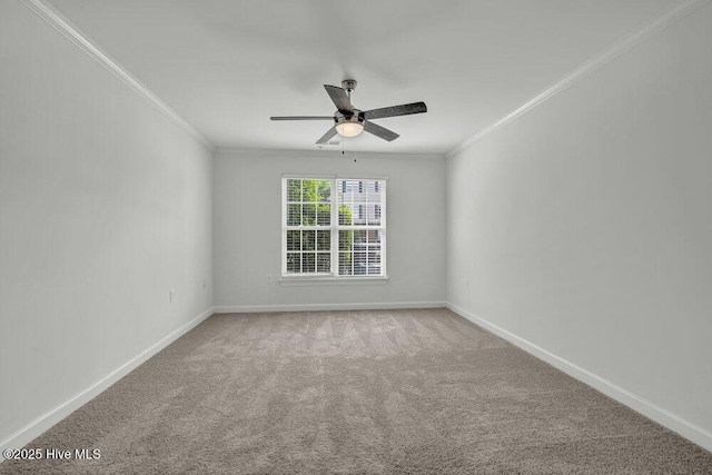 carpeted spare room featuring crown molding, baseboards, and a ceiling fan