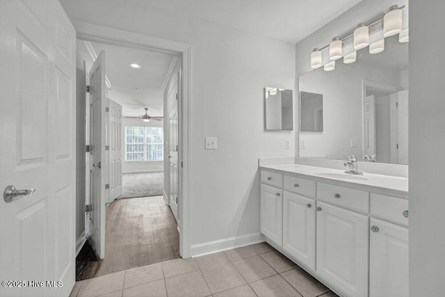bathroom featuring baseboards, vanity, ceiling fan, and wood finished floors