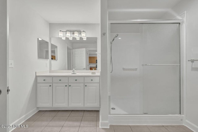 full bath with a stall shower, tile patterned flooring, and baseboards